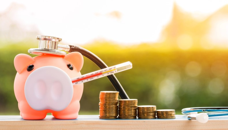 Piggy bank with a thermometer sticking out of its mouth