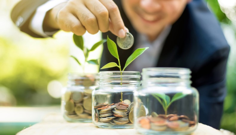 A man putting money into glass jars